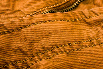 clothing items stonewashed cotton fabric texture with seams, clasps, buttons and rivets, macro