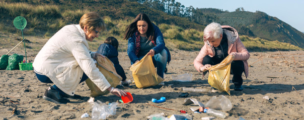 Group of female volunteers picking up trash on the beach