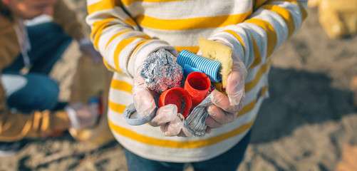 Detail of boy hands with garbage collected from the beach