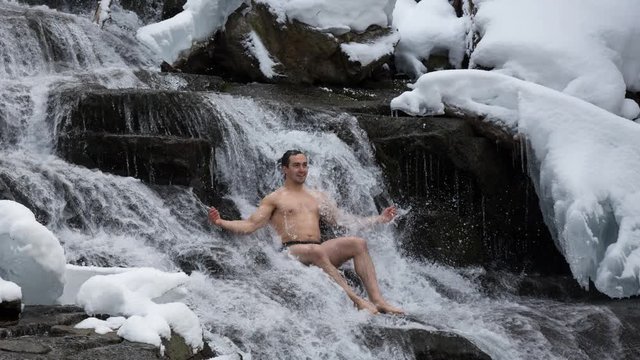 A male is practicing cold water immersion under the beautiful waterfall. Taken in Joffre Lakes, North of Vancouver, British Columbia, Canada. Still Image Continuous Animation