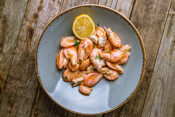 boiled shrimp on plate on wooden background