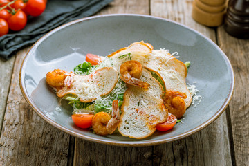 salad caesar with shrimps on grey plate