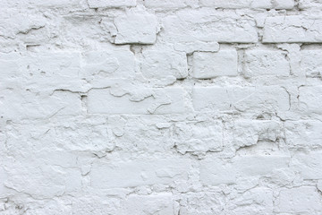 White brick wall, grunge texture background. The texture of the old brick wall is painted white with paint.