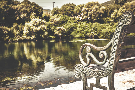 Vintage photo of the old bench next to the lake