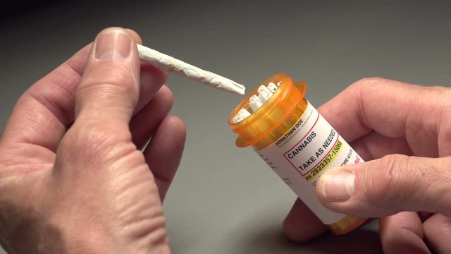 Man takes out a marijuana joint from bottle