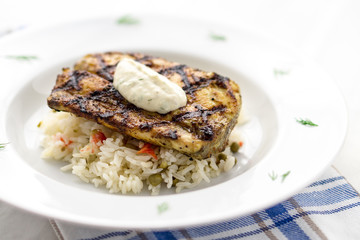 Mahi mahi grilled fish with rice closeup view. This lean tropical white fish is also known as common dolphinfish or dorado. Considered an healthy food rich in protein, it is perfect for bbq grilling.
