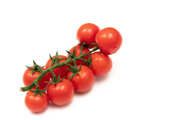 A branch of red cherry tomatoes on a white background. Small and juicy vegetable is rich in vitamins and trace elements. Healthy food. Fresh and organic vegetables. Raw food