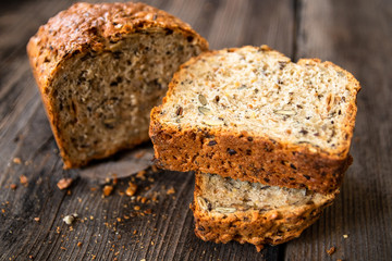 Homemade healthy freshly baked organic whole grain bread with healthy seeds on wooden table