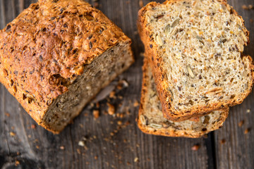 Homemade healthy freshly baked organic whole grain bread with healthy seeds on wooden table