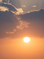 Obraz na płótnie Canvas Orange sun setting with clouds above