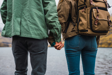 back view of a couple holding hands in front a lake in Faroe Island