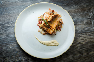 top view on roasted fish pieces served on meat salad