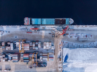 Container cargo ship loading North Arctic port. Concept freight transportation import export and business logistic, aerial view winter