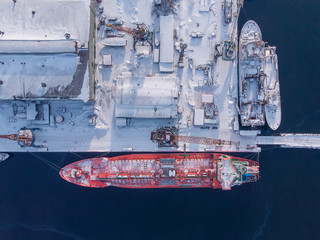 Commercial north arctic port is loading containers onto cargo tanker ship. Concept logistics and...