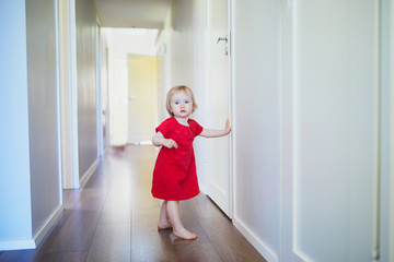 Fototapeta na wymiar Toddler girl in red dress at home