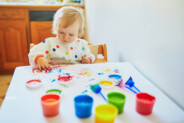 Adorable little girl painting with fingers