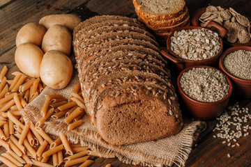 Wholegrain food pasta and freshly baked rye bread on table