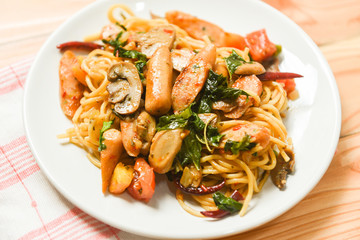 Hot and spicy Spaghetti Pasta tomato chilli and basil leaves top view - Traditional delicious Italian food spaghetti sausage on plate on the dining table