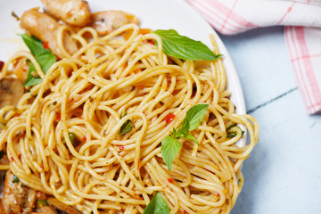 Spaghetti Pasta and tomato chilli and  basil leaves vegetables - Traditional delicious Italian food spaghetti bolognese on plate on the dining table
