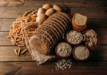 Wholegrain food pasta and freshly baked rye bread on table