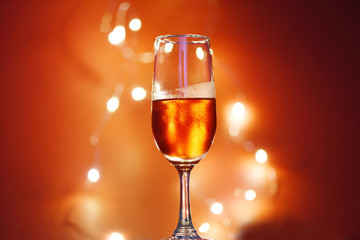 Champagne glass on table against blurred lights background - perspective of crystal clear wine glass for night party on the counter top bar restaurant