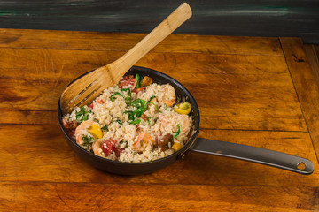 Stir Fry Skillet on Rustic Cutting Board filled with Shrimp in Rice with Mixture of Vegetables