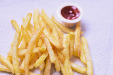 French fries on white paper with ketchup on dining