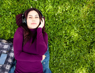 Cute young woman listening music with headphones.