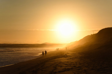 Fototapeta na wymiar Elderly Couple Walking On Afternoon Sunset Beach, Mossel Bay, South Africa