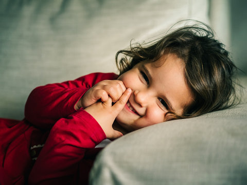 Portrait of smiling girl resting on pillow at home