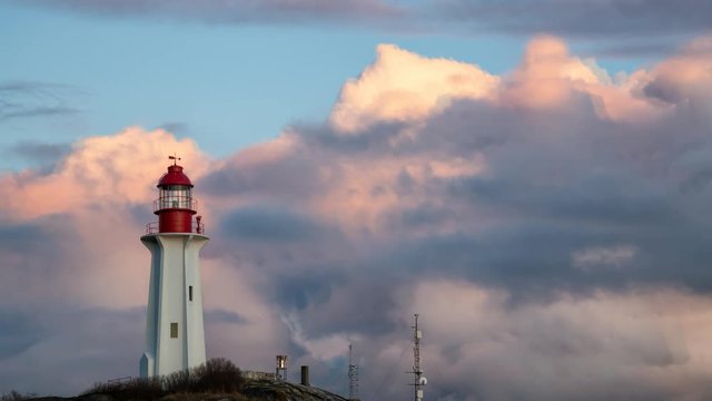 Lighthouse on a rocky shore during a vibrant cloudy sunset. Taken in Horseshoe Bay, West Vancouver, British Columbia, Canada. Still Image Continuous Animation