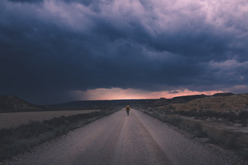 Man standing on road and looking at impressive evening sky
