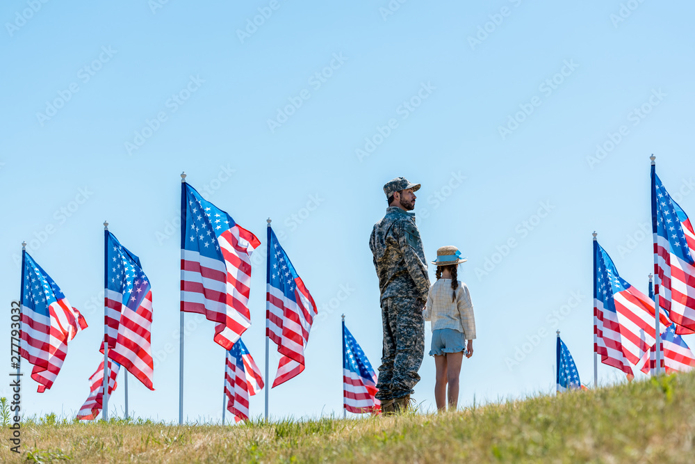 Canvas Prints military man in uniform standing with daughter near american flags