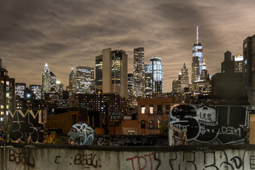 Manhattan bridge view over Chinatown at night, lower Manhattan in the background. New York City,...