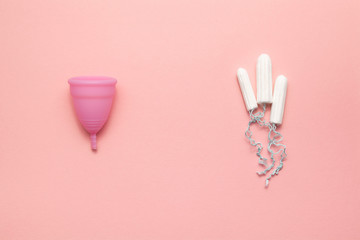 Reusable silicone menstrual cup and tampons comparison on a soft pink background. Modern female intimate alternative gynecological hygiene. Eco zero waste concept