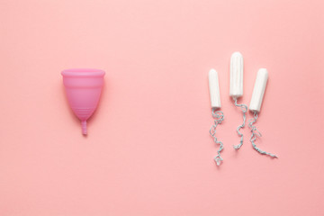 Reusable silicone menstrual cup and tampons comparison on a soft pink background. Modern female intimate alternative gynecological hygiene. Eco zero waste concept