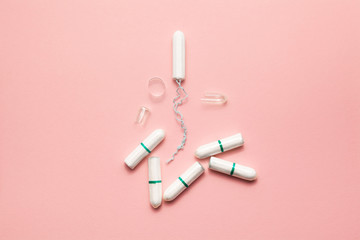 Unpacked tampons on a soft pink background. Modern female intimate gynecological hygiene. Eco zero...