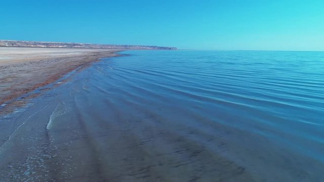 Sea foam at the beach of the Aral Sea near Aktumsuk cape at sunset in Karakalpakstan, Uzbekistan.