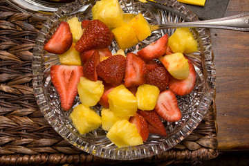 Glass bowel of fresh healthy strawberries and pineapple fruit appetizers. St Paul Minnesota MN USA