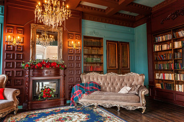 Luxury classic interior of home library. Sitting room with bookshelf, books, arm chair, sofa and...