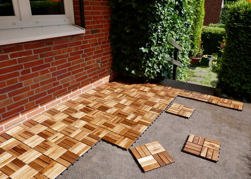 Lay wooden tiles on a terrace. Square wood panels are connected with Lock Clic