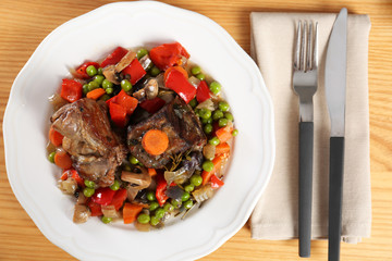Plate with meat and garnish prepared in multi cooker on table, flat lay