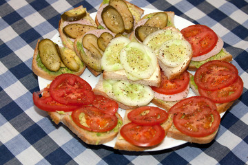Healthy polish snack sandwiches of sliced tomatoes, pickles and cucumbers sprinkled with pepper. Zawady Poland