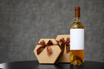 Gift boxes and bottle of wine on table. Space for design