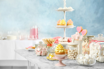 Fototapeta na wymiar Candy bar with different sweets on white marble table indoors. Space for text