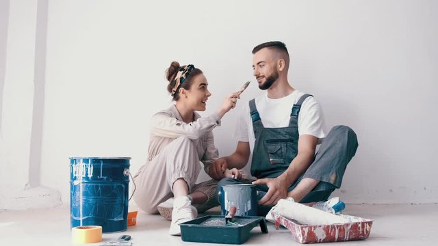 happy couple in love painting their first apartment together