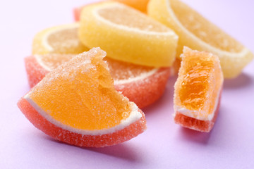 Tasty bright jelly candies on color background