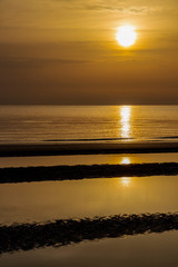 Golden summer sunrise at the Adriatic Coast, sun glitter on the water surface, at Lungomare Dante Alighieri beach in Senigallia, Province of Ancona, Marche, Italy