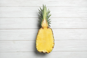 Half of fresh pineapple on white wooden background, top view