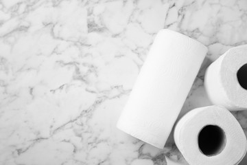 Rolls of paper towels on marble table, top view. Space for text